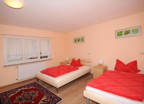 - une chambre avec 2 lits dotés d'oreillers rouges et d'une fenêtre dans l'établissement Exclusiv Apartment Rödermark 3 Schlafzimmer, à Rödermark