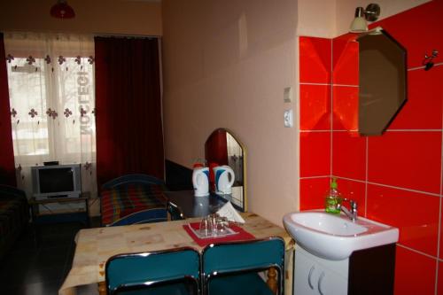 a bathroom with a sink and a table with chairs at Pokoje Goscinne Koral in Radomsko
