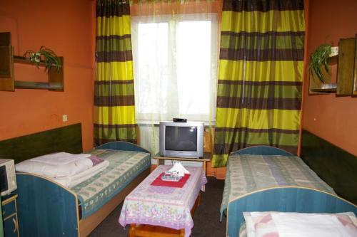 a room with two beds and a tv and a window at Pokoje Goscinne Koral in Radomsko