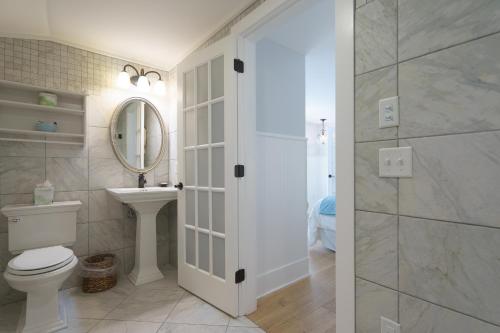 a bathroom with a toilet and a sink and a mirror at Marginal Way House in Ogunquit