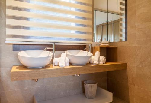 a bathroom with two sinks on a shelf with a mirror at A Maquia in Poio