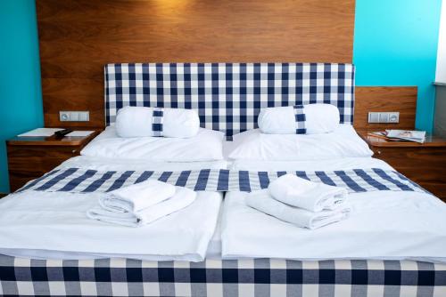 ブルノにあるレストラン＆デザイン ホテル ノエム アーチのベッド(白いタオル付)