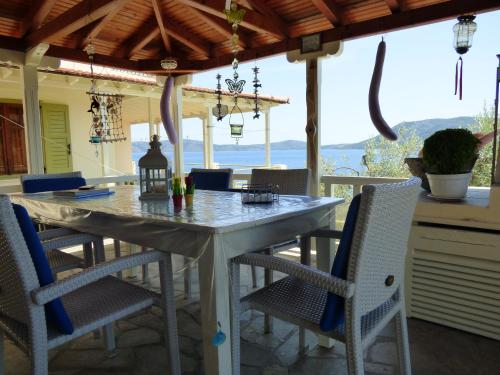 a table and chairs on a patio with a view of the ocean at Odyssia near the Seaside in Aghios Petros Alonissos