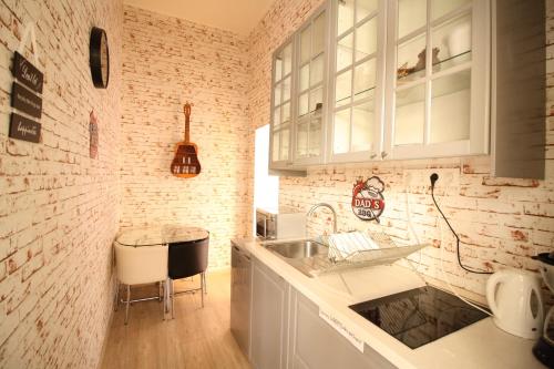 cocina con fregadero y pared de ladrillo en Susan Apartment near Blaha Lujza Square, en Budapest