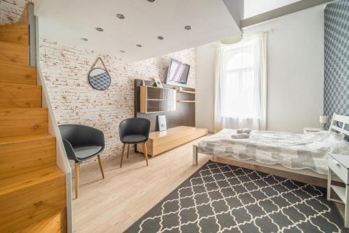 a bedroom with a bed and two chairs at Susan Apartment near Blaha Lujza Square in Budapest