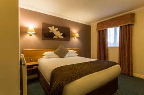 a hotel room with a bed and a window at Holt Lodge Hotel in Wrexham