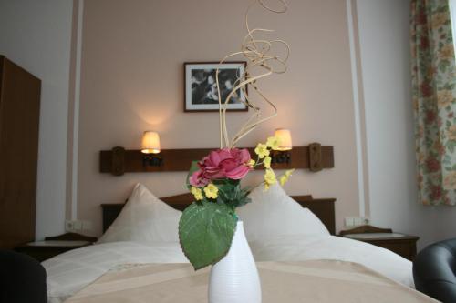 a vase filled with flowers sitting on top of a bed at Gasthof Grünling in Wallsee