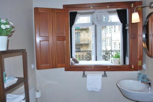 a bathroom with a sink and a window at Pensión Acibeche in Santiago de Compostela