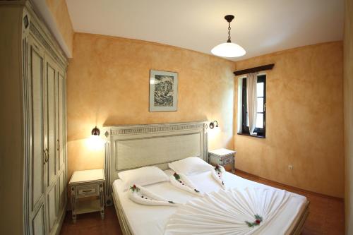 a bedroom with a large white bed with two pillows at Duni Holiday Village - All Inclusive in Sozopol