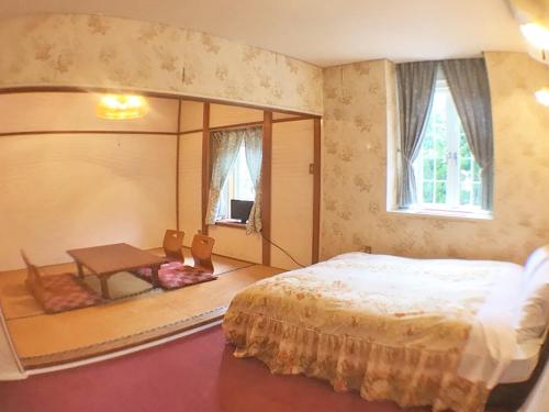 Ένα ή περισσότερα κρεβάτια σε δωμάτιο στο ペンション百万本のバラ "A Million Roses"