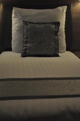 a black pillow sitting on top of a bed at The Concert Hotel in Amsterdam
