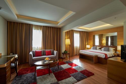 una camera d'albergo con letto e divano di Coral Beach Hotel And Resort Beirut a Beirut