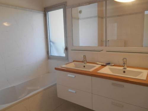 une salle de bain avec deux lavabos, un miroir et une baignoire dans l'établissement Appartement Le France - Vacances Côte d'Azur, à Mandelieu-la-Napoule