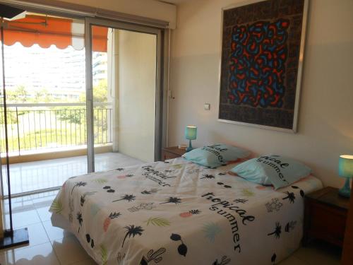 マンドリュー・ラ・ナプールにあるAppartement Le France - Vacances Côte d'Azurのベッドルーム1室(ベッド1台、大きな窓付)