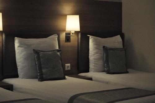 two beds with pillows in a hotel room at The Concert Hotel in Amsterdam