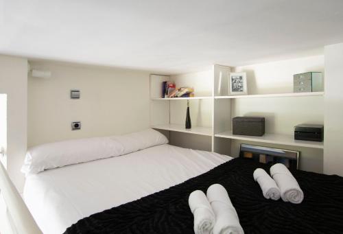 Un dormitorio con una cama blanca con toallas blancas. en Plaza de Carros, 3, en Madrid