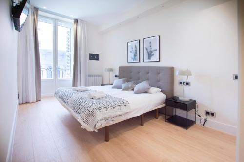 een witte slaapkamer met een groot bed en een raam bij Minty Stay - Paz in Madrid