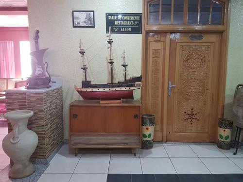 una habitación con un barco modelo en una mesa junto a una puerta en Charm El Cheikh Hotel, en Orán