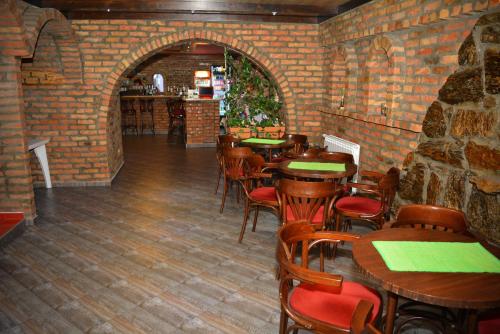 a restaurant with tables and chairs and a brick wall at Deltix Apartments in Vršac