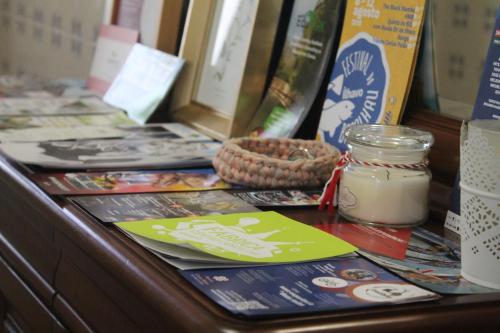 a counter with many books and a jar of food at Casa das Camélias in Aveiro
