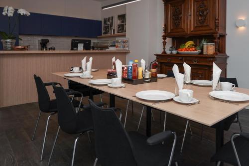 a long table with chairs and plates on it at Amistad hotel in Amsterdam
