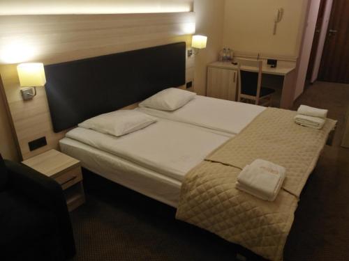 a bedroom with a bed with two towels on it at Spa Hotel Gloria in Przemyśl