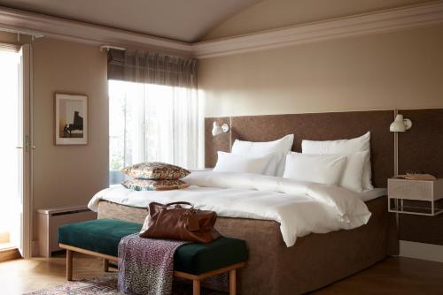 a bedroom with a large bed with a large window at Hotel St. George Helsinki in Helsinki