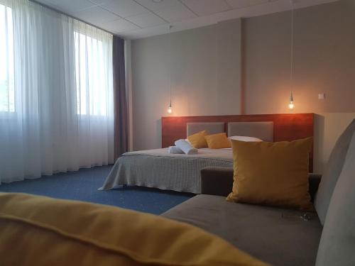 a bedroom with a bed and a couch in it at Hotel CITY in Prnjavor