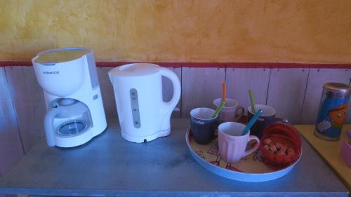 a counter with two coffee makers and cups on it at Chez Clairotte in Salinelles