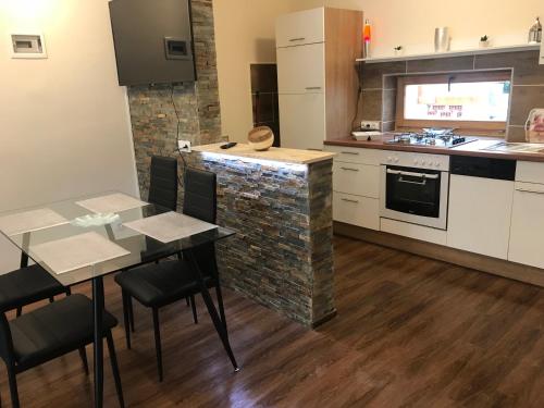 a kitchen with a table and a stone wall at Candy Apartman in Keszthely