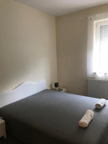 a bedroom with a large bed with two towels on it at Candy Apartman in Keszthely