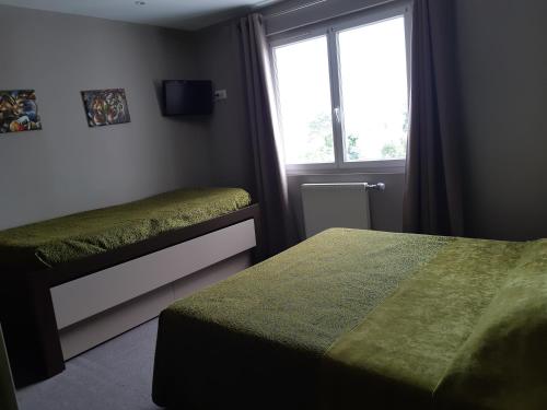 a bedroom with two beds and a window at Hôtel Savary in La Rochelle