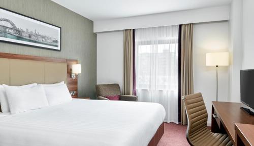 um quarto de hotel com uma cama, uma secretária e uma televisão em Leonardo Hotel Newcastle Quayside em Newcastle upon Tyne