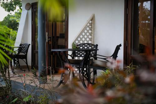 a bike parked next to a bench on a porch at Auberge d'Anse Boileau & Restaurant Chez Plume in Anse Boileau