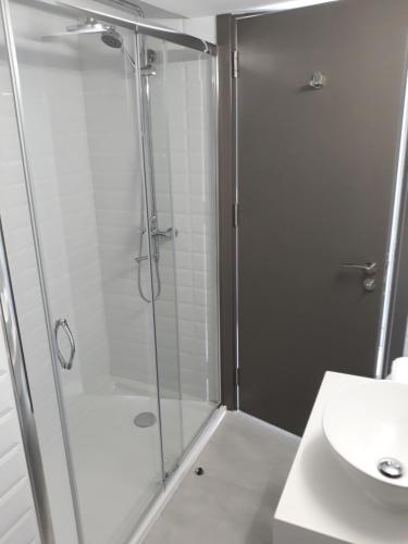 a shower with a glass door next to a sink at Protaras Plaza Hotel in Protaras