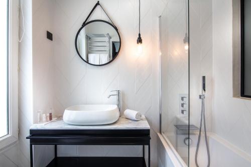 a bathroom with a sink and a mirror on a counter at Hôtel Royal Opéra in Paris