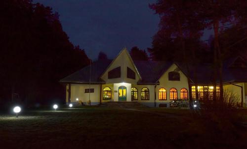 a large white house at night with lights on at Motel Brencis in Iecava