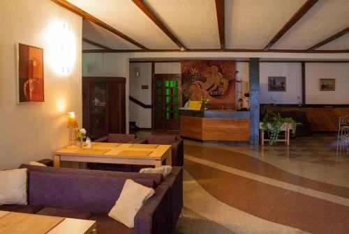 a living room with couches and a table and a counter at Motel Brencis in Iecava