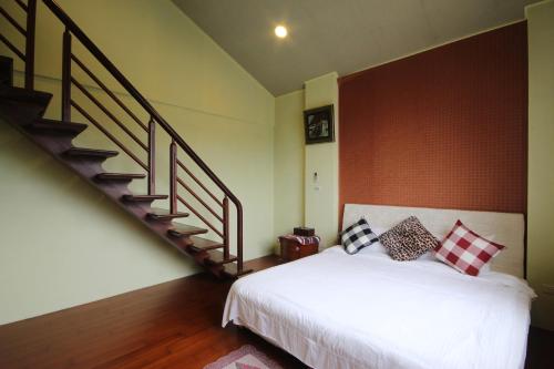 a bedroom with a white bed and a staircase at Star House in Tianfu