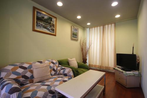 a living room with a couch and a tv at Star House in Tianfu