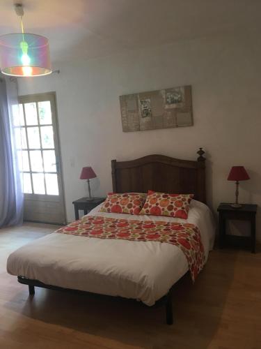 a bedroom with a bed and two lamps and a window at Auberge de Rustréou in Rustrel