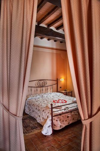 a bedroom with a bed with curtains around it at Agriturismo Sanguineto in Acquaviva