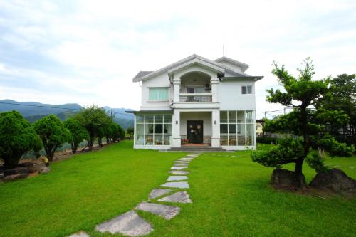 a house on a hill with a green lawn at Star House in Tianfu