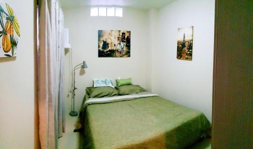 a bed in a room with two pictures on the wall at Mailz Haven 7-2BR Apartment in Davao City