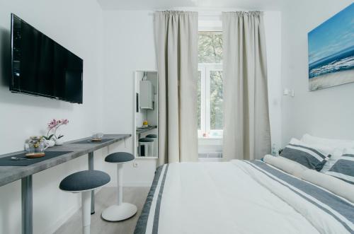 a white bedroom with a large bed and a desk at SIA Downtown Apartments in Zagreb