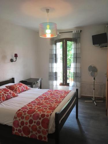 - une chambre avec un grand lit et une fenêtre dans l'établissement Auberge de Rustréou, à Rustrel