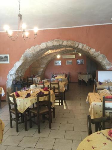 une salle à manger avec des tables et une voûte en pierre dans l'établissement Auberge de Rustréou, à Rustrel