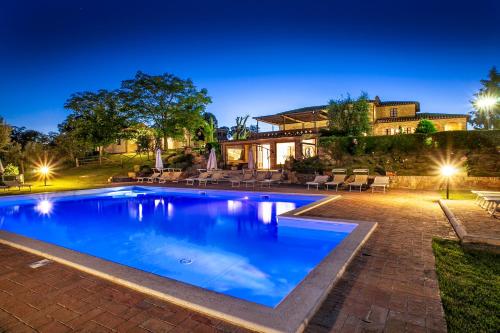 a swimming pool in front of a house at Agriturismo Sanguineto in Acquaviva