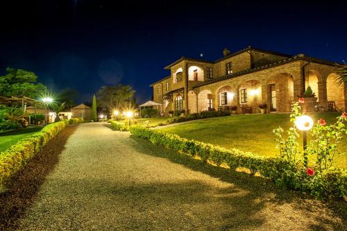 a house at night with lights on a driveway at Agriturismo Sanguineto in Acquaviva