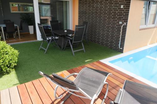 a patio with chairs and a table next to a swimming pool at Anitas Ferienhaus in Cochem